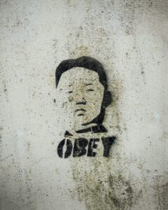 Graffiti on a gray wall of Kim Jong Un over the word Obey